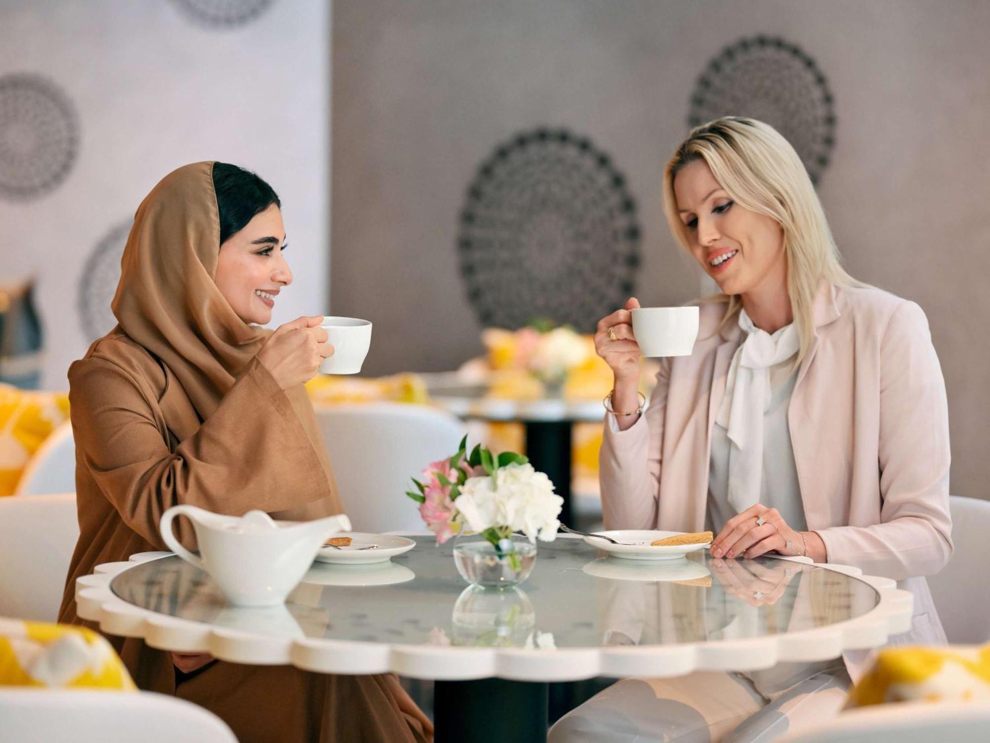 Moevenpick Hotel & Apartments Ghala มัสกัต ภายนอก รูปภาพ Two women drinking coffee